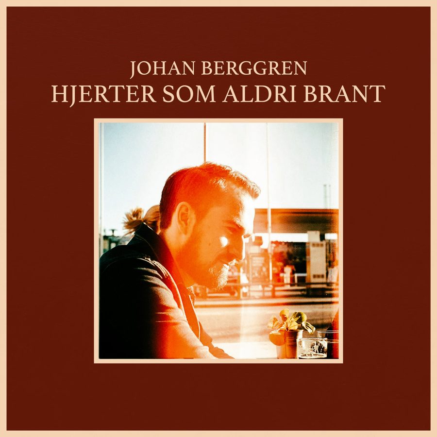 Coveret til Hjerter som aldri brant: Johan i motlys på rød bunn.